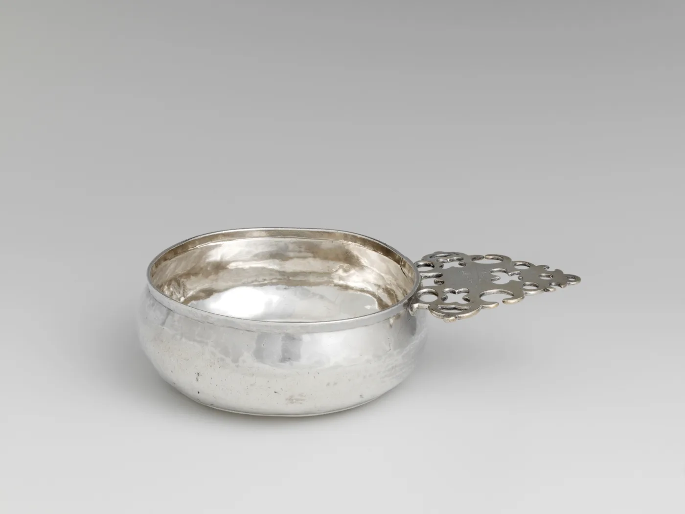 Silver porringer by Samuel Vernon of Newport Rhode Island with a geometric pierced handle around a solid engraved centre panel