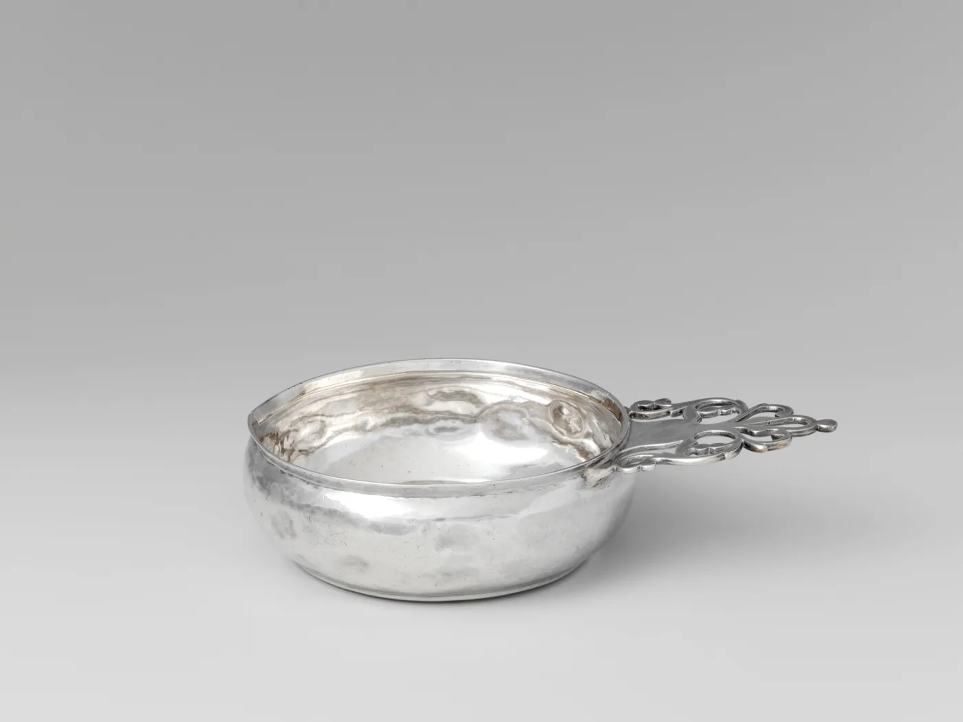 Silver porringer by Samuel Edwards of Boston with a keyhole handle, a round opening above a tapering slot flanked by scrolls
