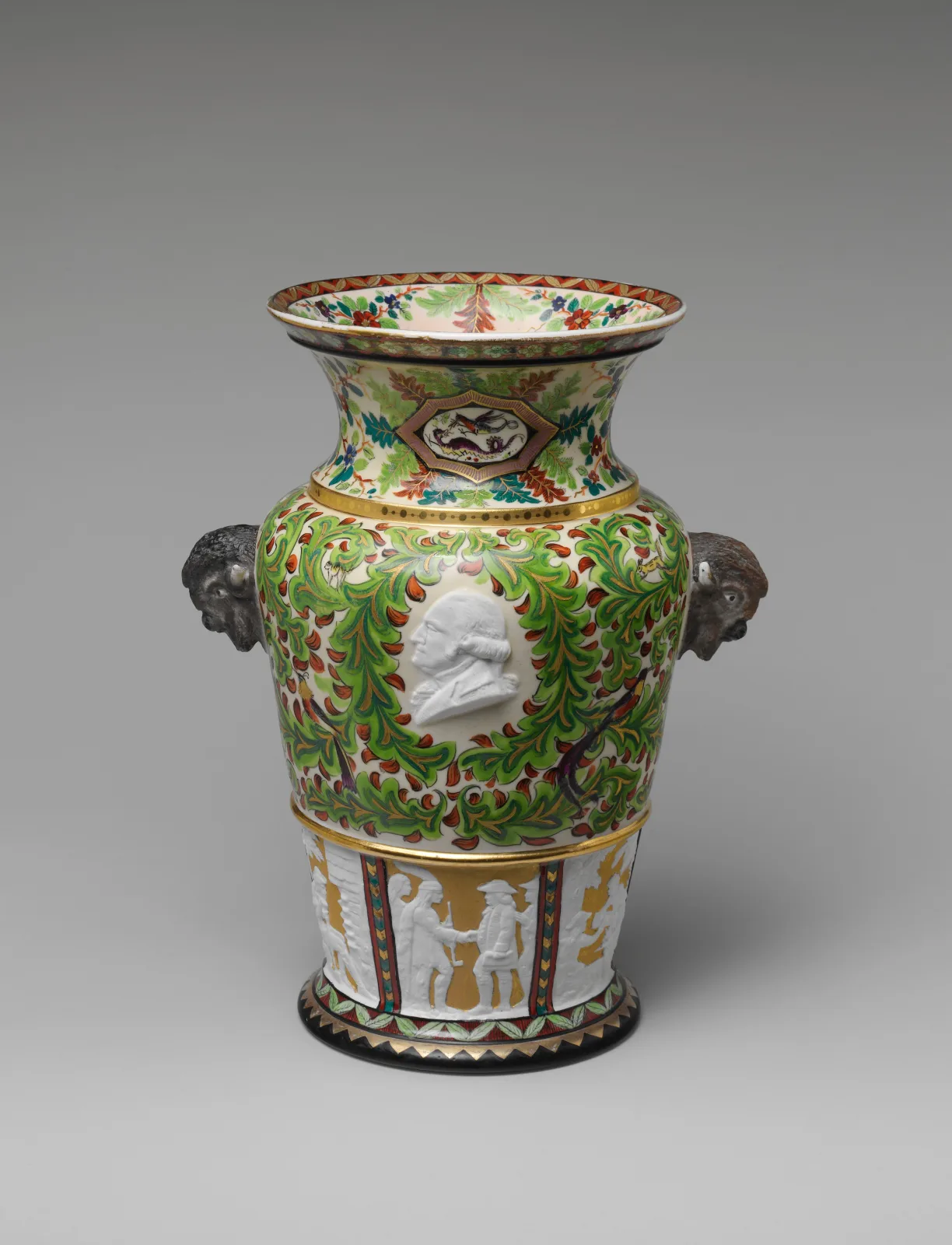 Tall porcelain vase with a green and gilt ground, moulded animal-head handles and a white relief portrait medallion set into the body above a frieze of figures