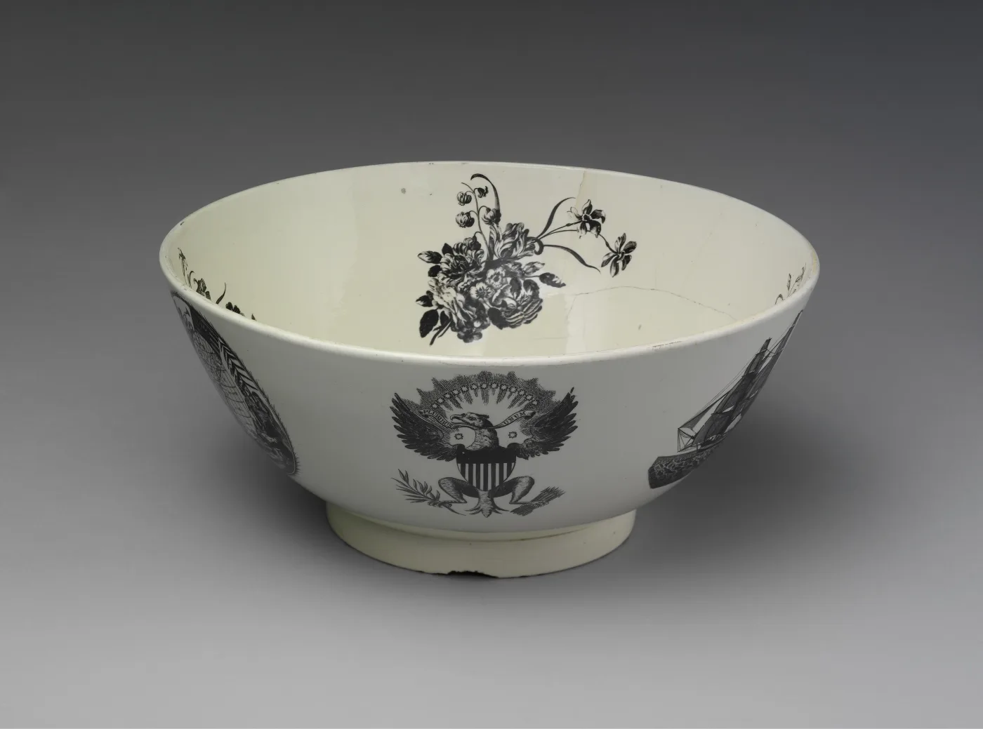 Creamware punch bowl printed in black with a spread eagle bearing a striped shield beneath a floral spray, seen from above and slightly to one side