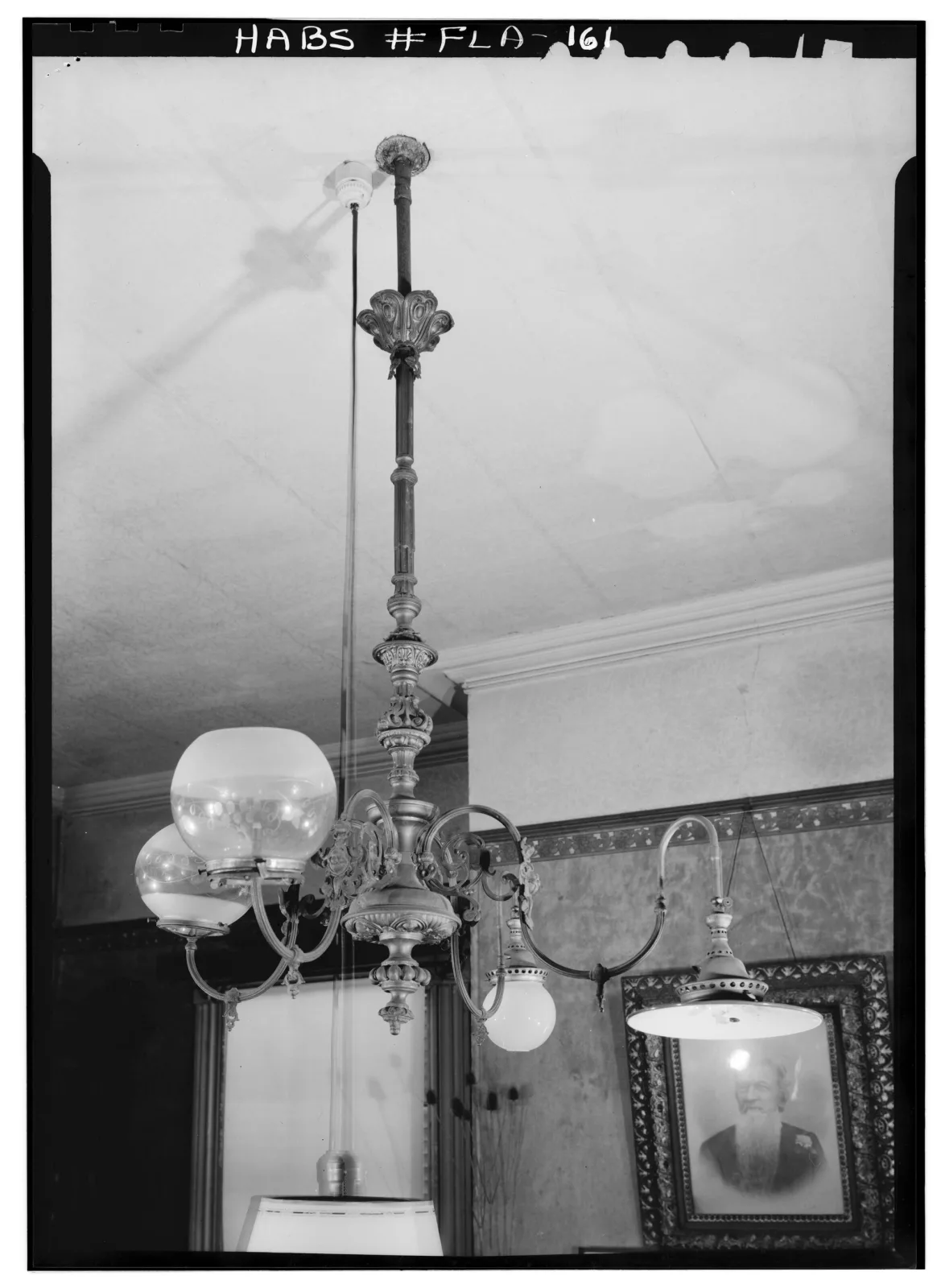 Survey photograph of a ceiling gas fixture whose arms curve upward, each carrying a glass globe