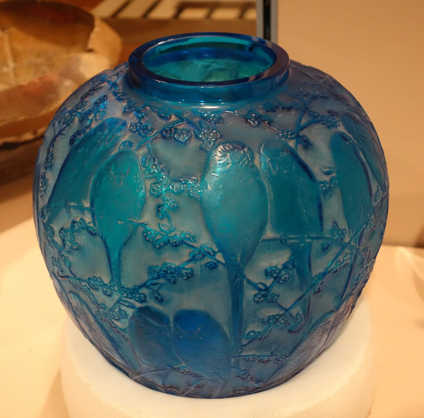 Globular vase in deep electric blue glass moulded with budgerigars perched among blossom branches