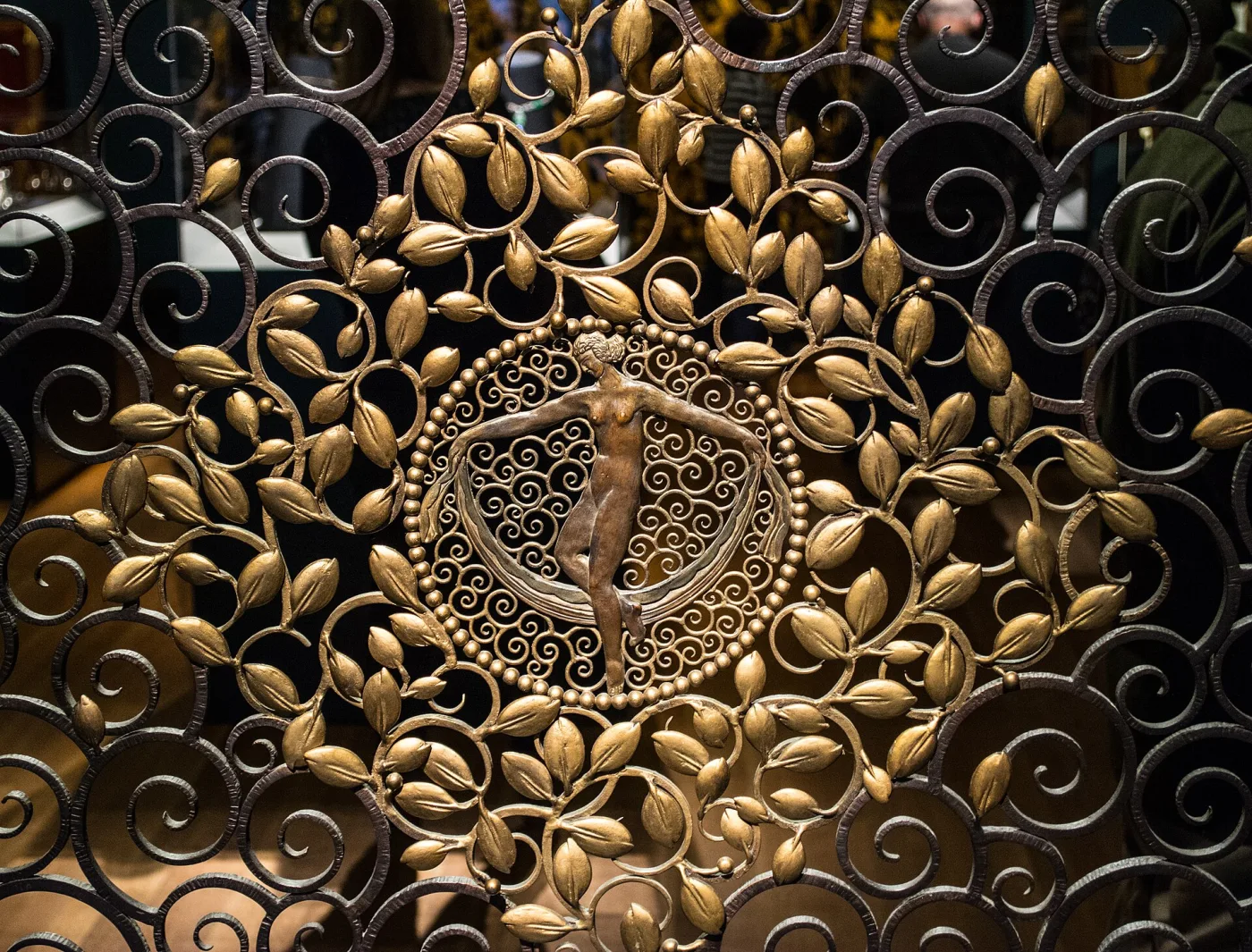 Close view of the gilded centre of the same screen: a female figure surrounded by gilded leaves, beading and dense scrollwork
