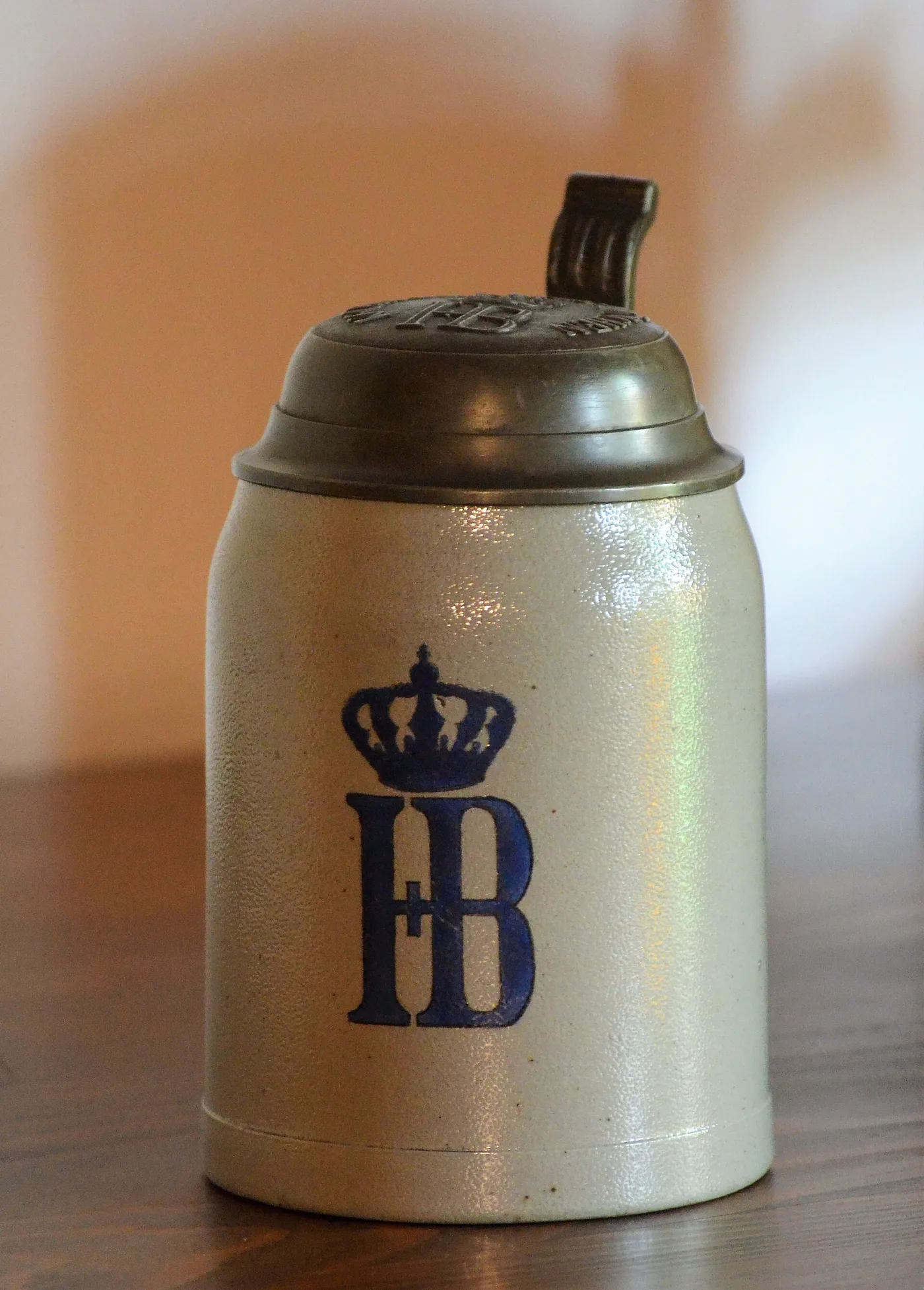Grey stoneware beer mug marked in blue with a crowned HB monogram and a pewter lid
