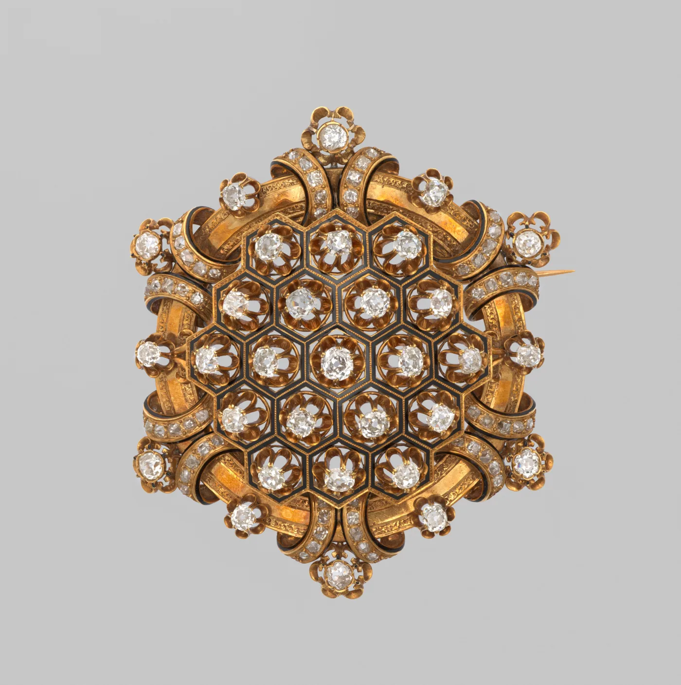 Hexagonal gold brooch with black enamel panels, cushion-cut diamonds in gold collets and a diamond-set ribbon border