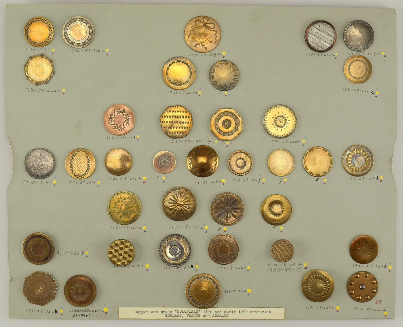 Museum study card holding about thirty-seven copper and brass buttons of the 18th and early 19th centuries, each pinned in place above a handwritten accession number, with a printed label along the bottom edge