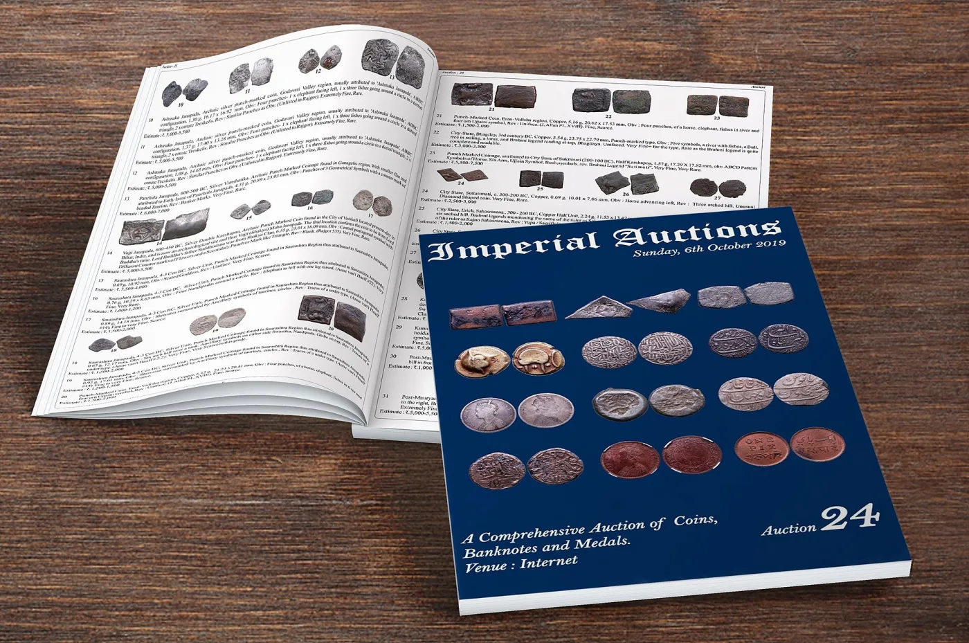 Auction catalogue lying open on a table, one page a grid of photographed coins with lot numbers, the facing page dense with descriptions