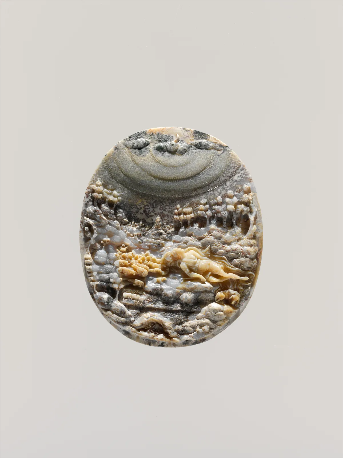 Oval moss agate cameo showing a sleeping shepherdess and her flock in a landscape, where the stone's natural mossy and cloud-like inclusions read as trees, foliage and sky, with only the figure and animals carved in relief