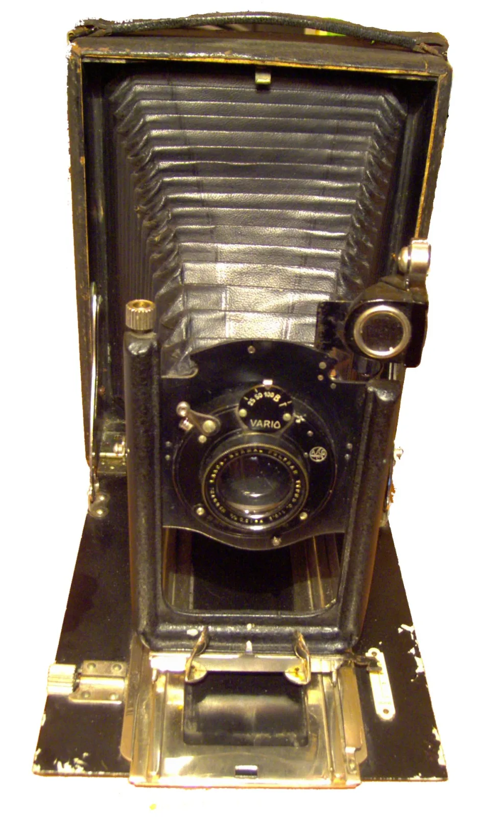 Early bellows camera of polished wood and brass standing on its baseboard, with a square-cornered leather bellows, a brass lens barrel and brass fittings, photographed under warm light