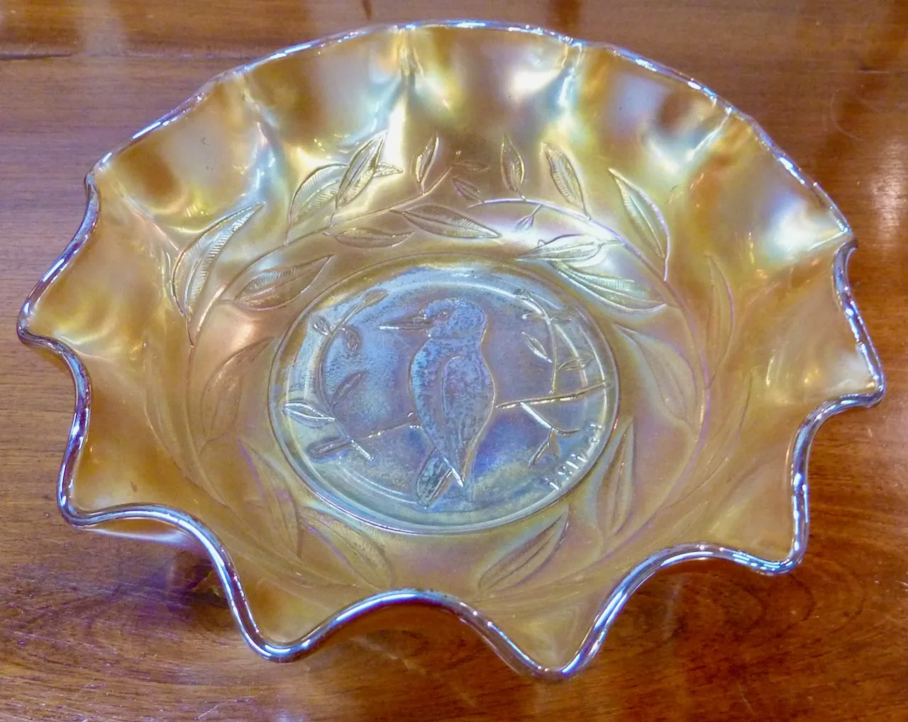 The same ruffled carnival glass bowl at the same angle without flash, now reading cool blue-white and silver