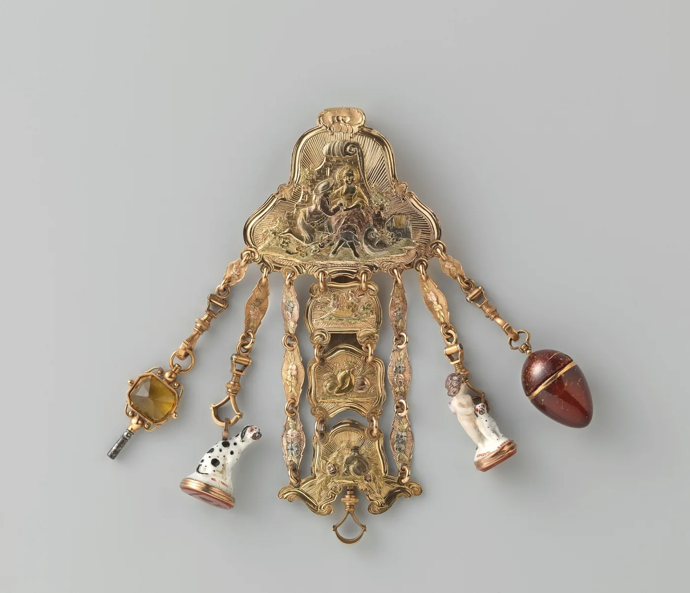 Gold chatelaine chased with a shepherd and shepherdess, hung with hardstone seals and a small porcelain figure