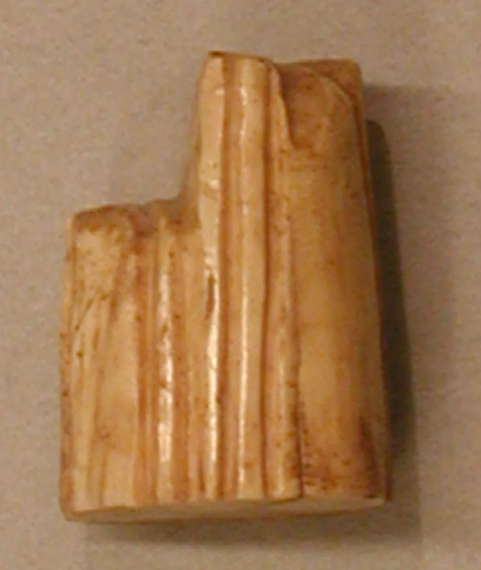 Abstract stepped chess piece in pale ivory, taller than it is wide, with a small projection at one side of the top