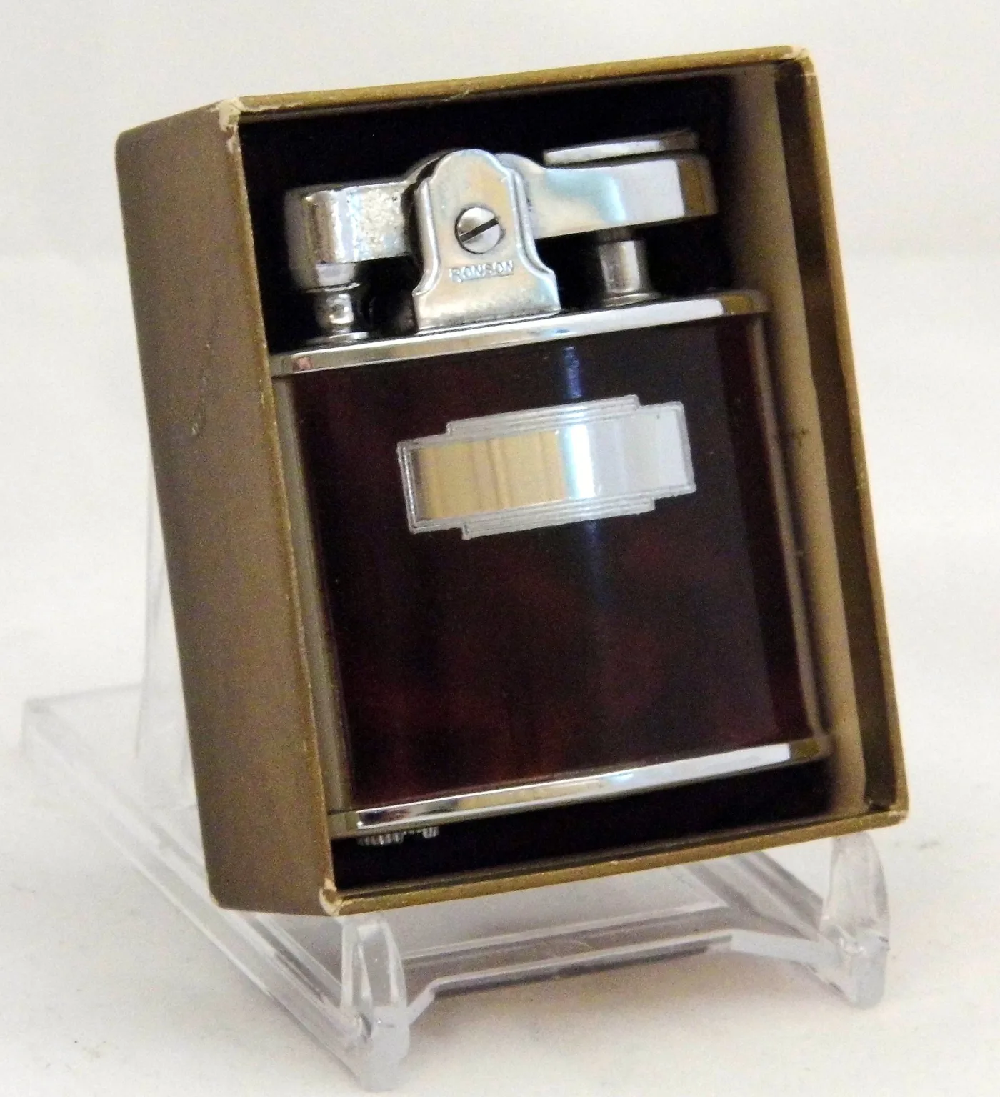 Dark red enamelled pocket lighter in its gilt presentation box, with a chrome lever arm stamped RONSON and a chrome Art Deco cartouche on the body