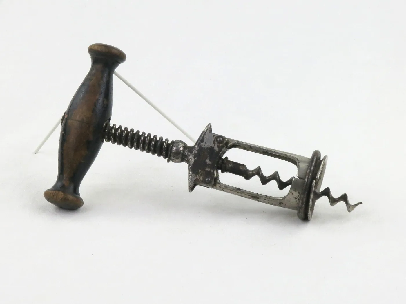 Corkscrew with a turned wooden handle on a threaded shaft running through a toothed rack inside an open frame that ends in a bottle collar