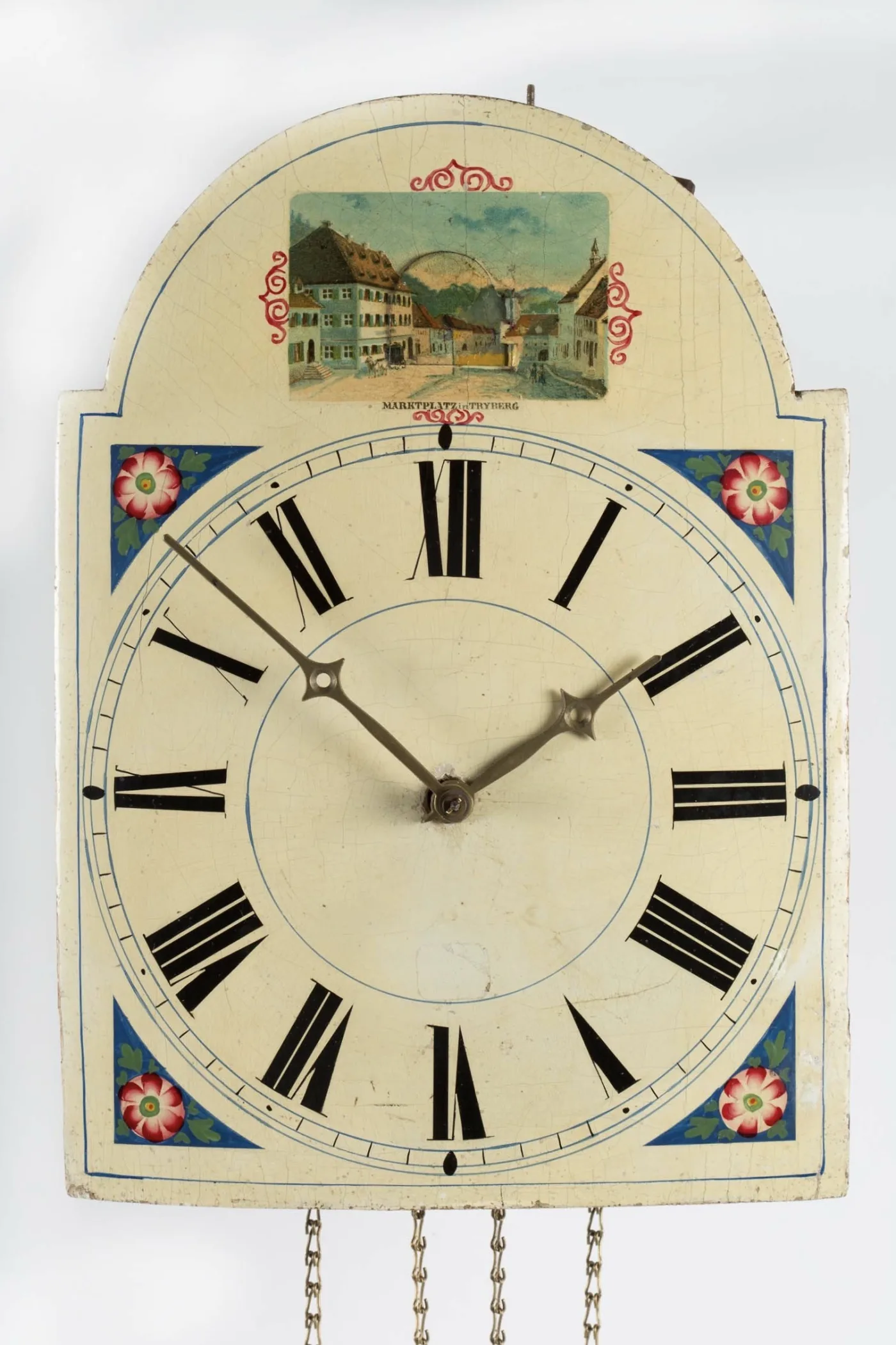 Lacquered shield clock dial with blue corner spandrels, painted roses and a topographical view of a market square in the arch