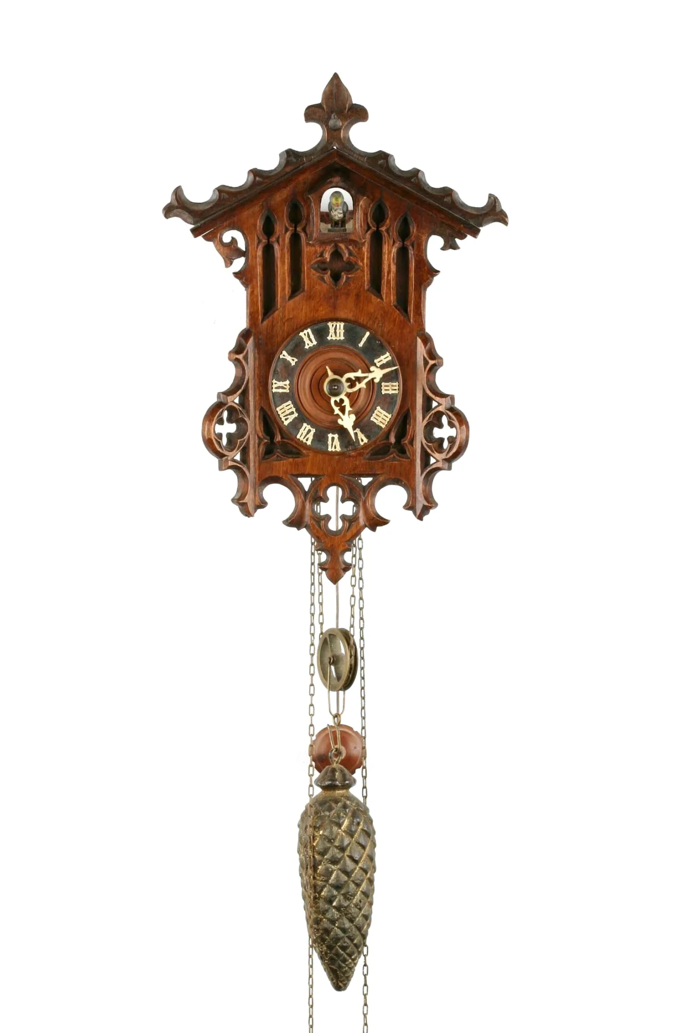 Gothic-style fretwork cuckoo clock with a pierced case and cuckoo door in the gable, hanging chains running over a brass pulley to a cast pine-cone weight