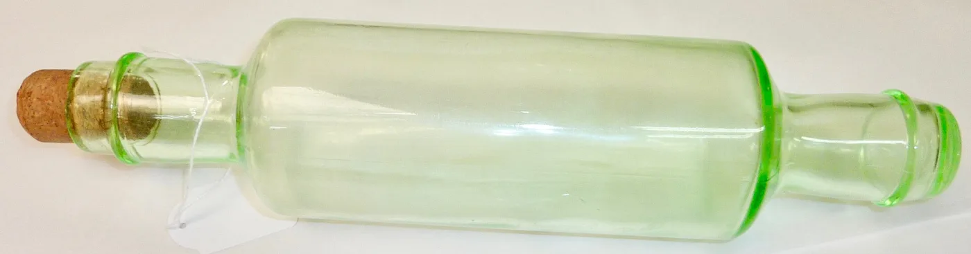 Long pale green glass rolling pin with turned handles and a cork stopper in one end