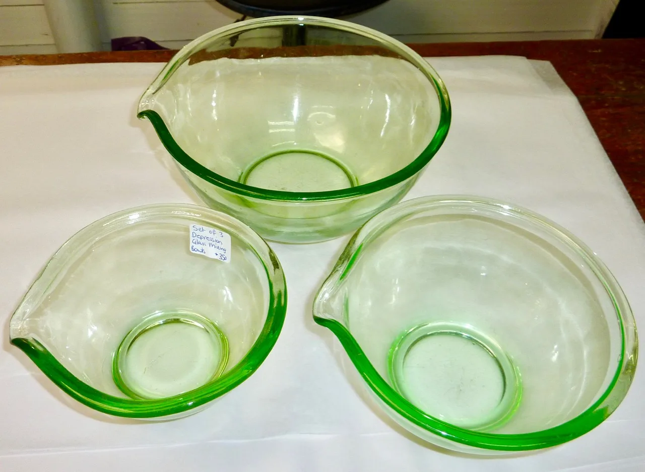 Three nesting green glass mixing bowls with pouring spouts and small handles, one still carrying a price sticker