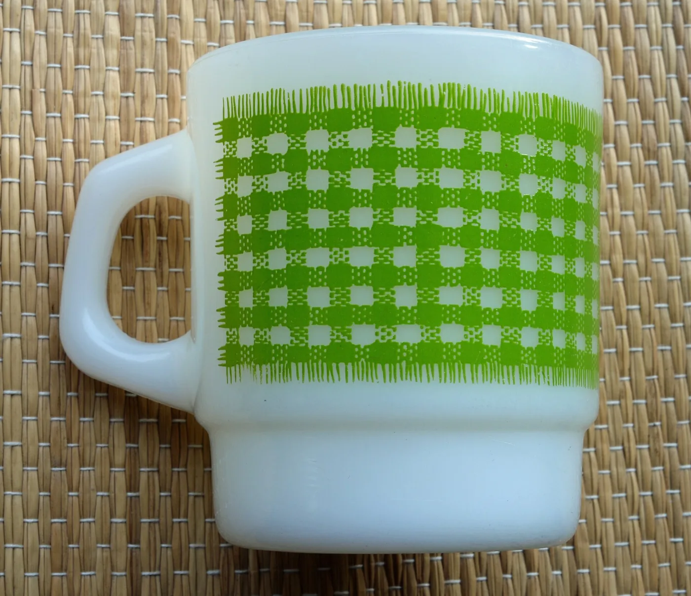 White glass mug with a green gingham check band printed round it and a solid handle