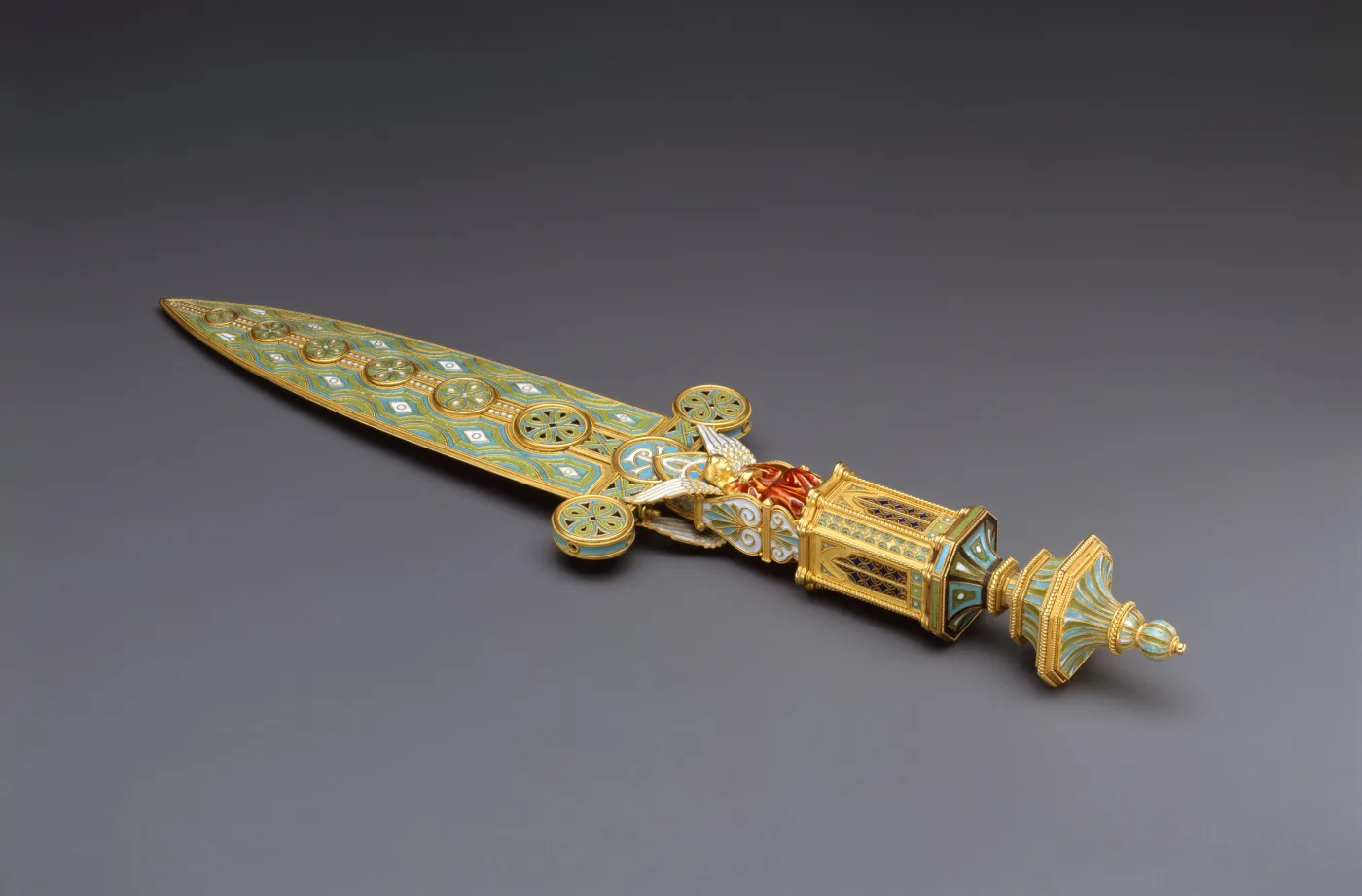 Long tapering blade inlaid along its whole length with small circular micromosaic roundels in green, blue and gold, set into an elaborate gold handle with a domed and finialed pommel