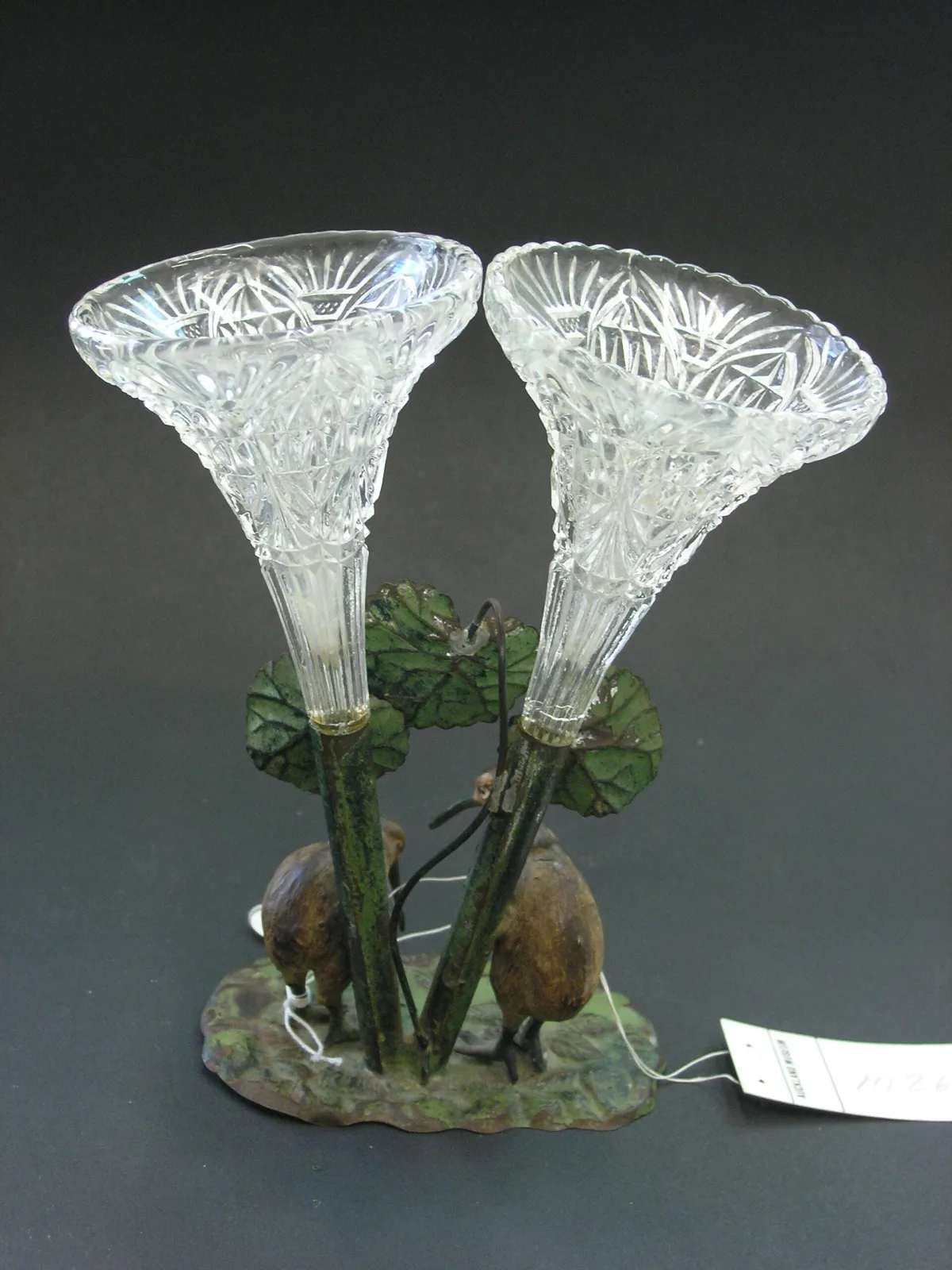 Glass epergne of three tall fluted trumpet vases with frilled rims rising from a naturalistic painted base modelled with green leaves and small brown birds