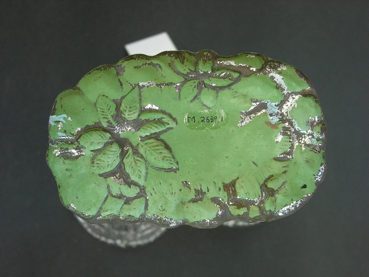 The same epergne seen from directly above, showing the green modelled base as a flat leaf-shaped tray with three empty circular sockets where the trumpet vases stand