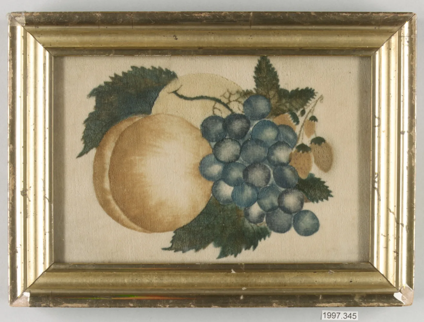 Framed theorem painting on velvet showing a peach, a bunch of blue grapes and serrated leaves