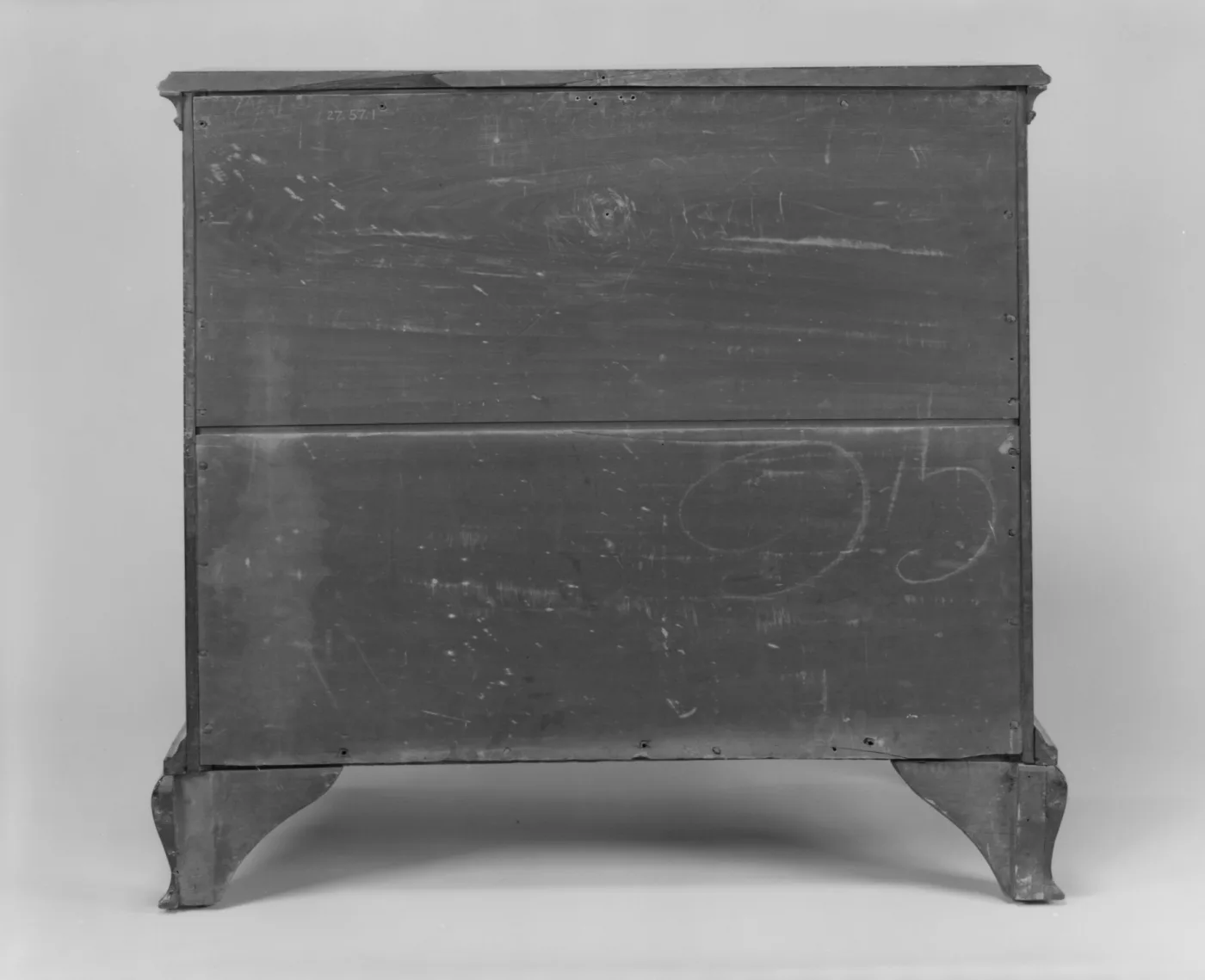 Black and white photograph of the back of a chest of drawers: two wide horizontal boards with nail holes along their edges, large chalk numerals on the lower board and a museum number painted at the top