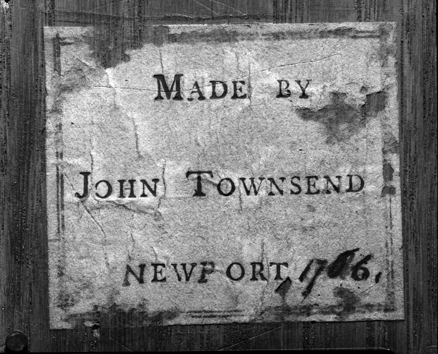 Printed paper label reading Made by John Townsend, Newport, with the year written in ink after the place name, glued to dark wood
