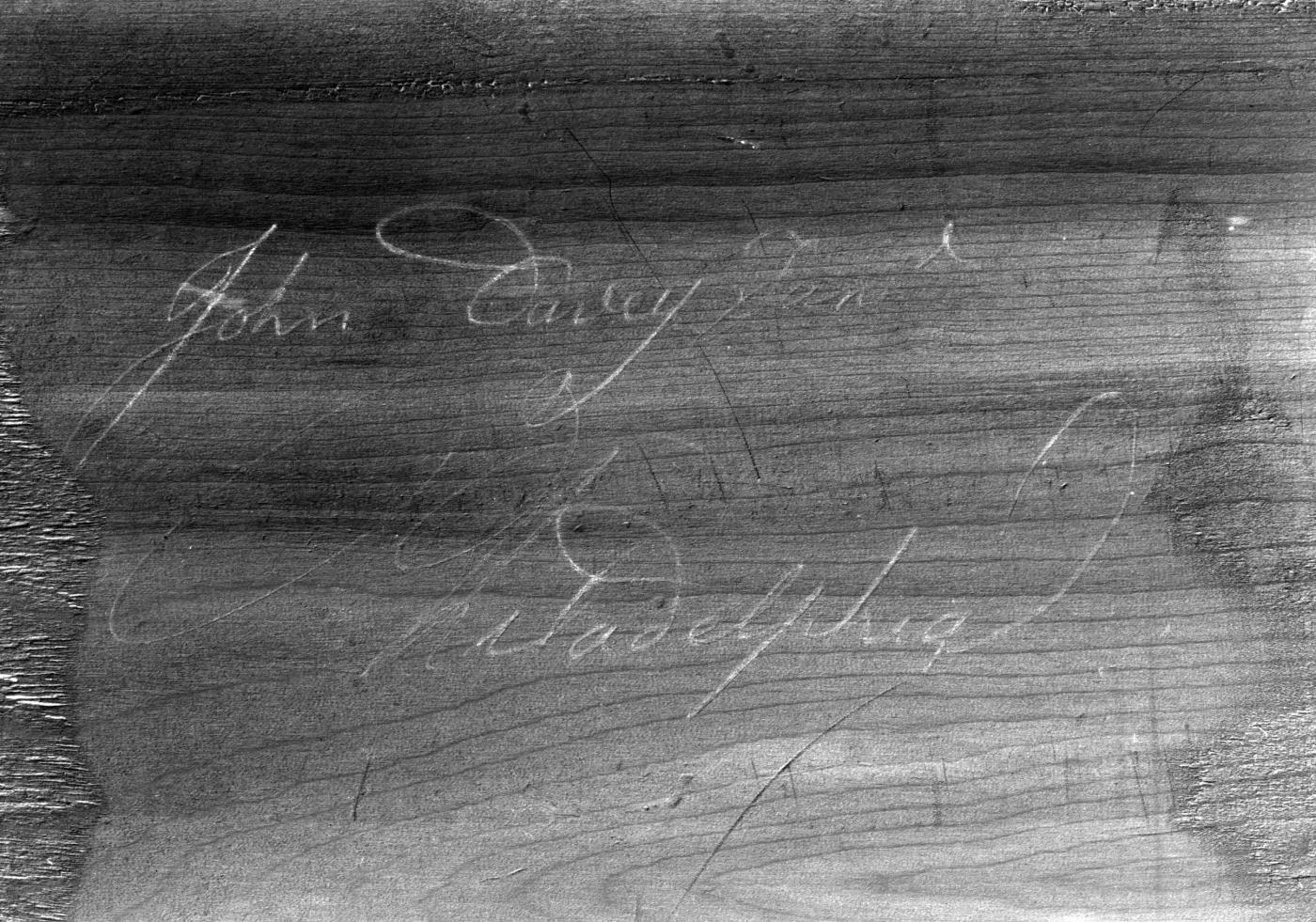 Unfinished wood board with a faint handwritten inscription in script reading John Davey and, below it, Philadelphia