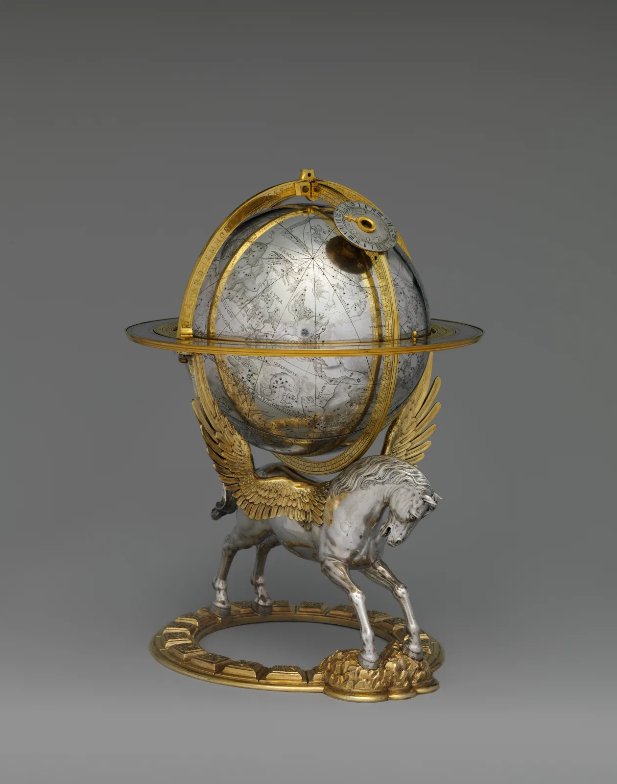 Small silver celestial globe engraved with constellation figures, held inside a gilded meridian ring and carried on the back of a winged horse standing on a gilt base