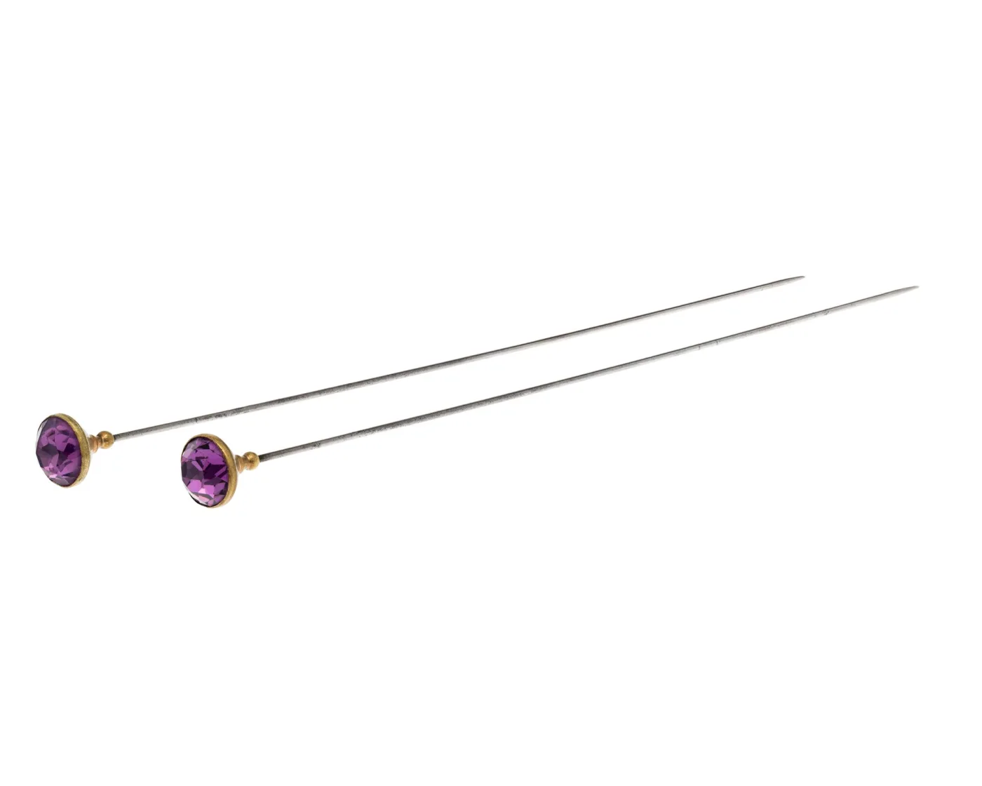 Two hat pins with large faceted purple stones in gilt brass mounts, on plain steel shafts
