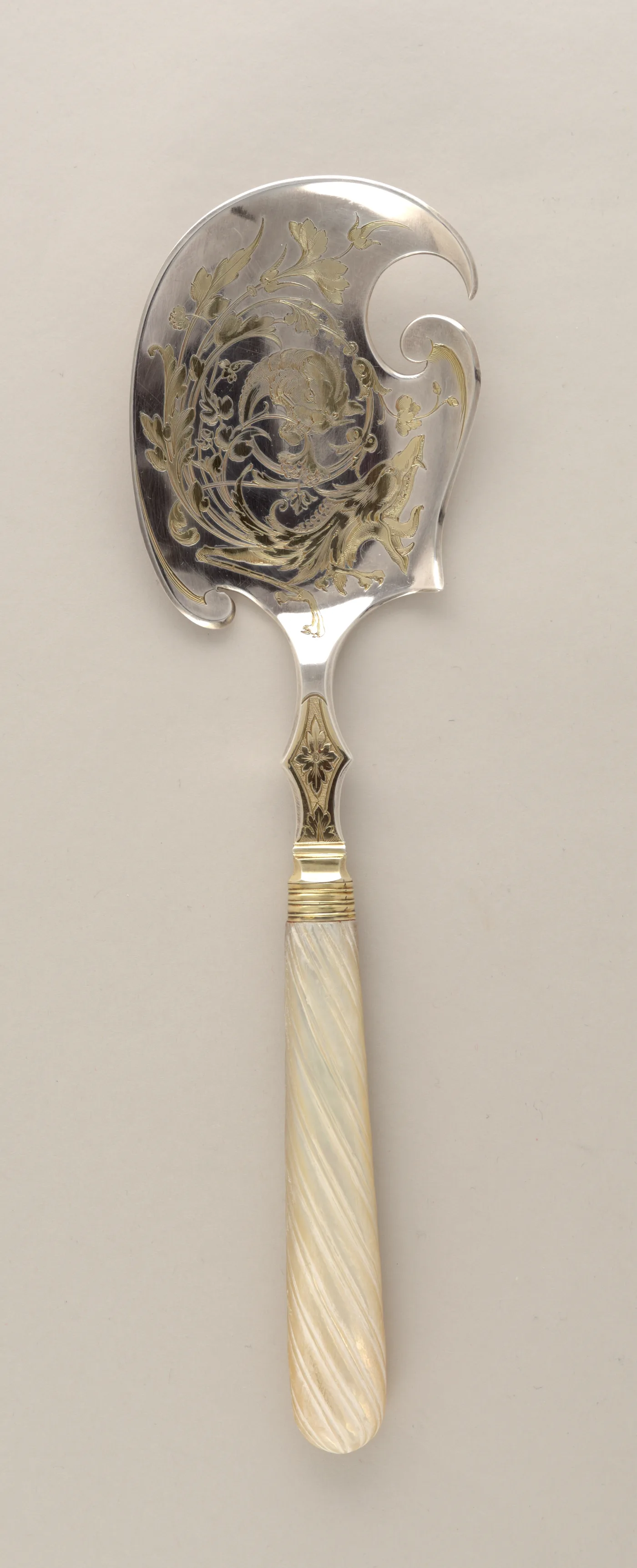 Silver ice cream server with a broad curled blade engraved and gilded with grotesque ornament, and a spiral-fluted mother-of-pearl handle