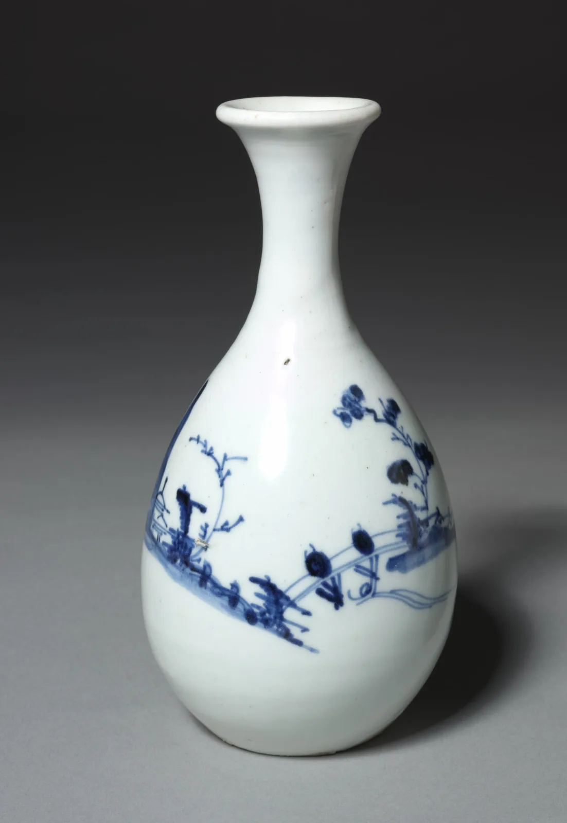 Tall Arita porcelain sake bottle with a swelling body and a narrow neck, painted in underglaze blue and iron red with scrolling foliage and flowers on a white ground