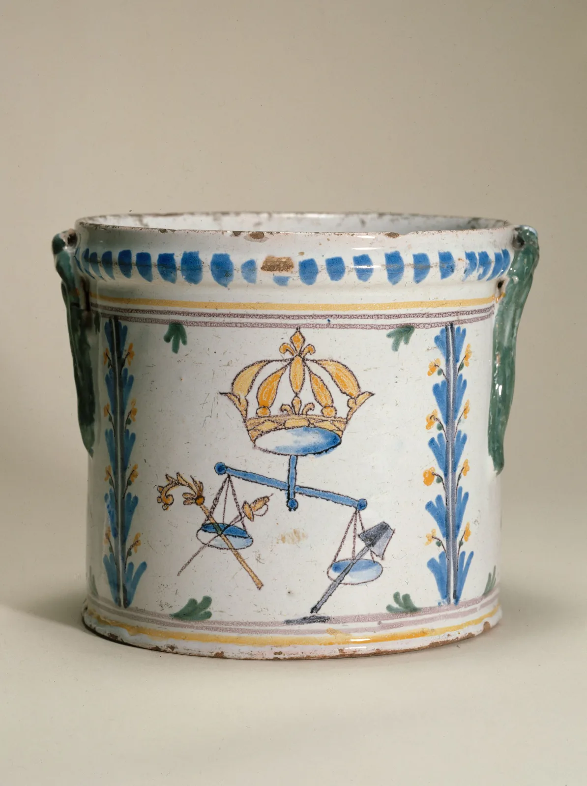 Nevers faience cylinder of 1789 to 1792 painted with a French royal crown above a balance, one pan holding clergy and nobility emblems and the lower pan holding those of the Third Estate, with blue and yellow foliate sprigs either side