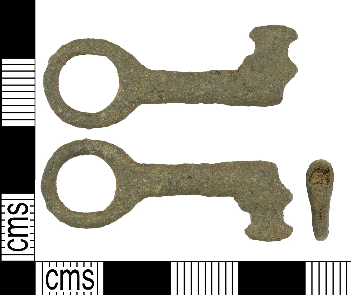 Two views of a small copper-alloy key with a circular bow and a square bit, laid against a centimetre scale that shows it to be under four centimetres long overall