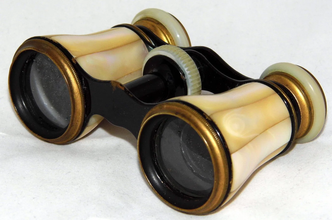 Opera glasses with cream mother-of-pearl barrels, black lacquered fittings and a pearl focus wheel