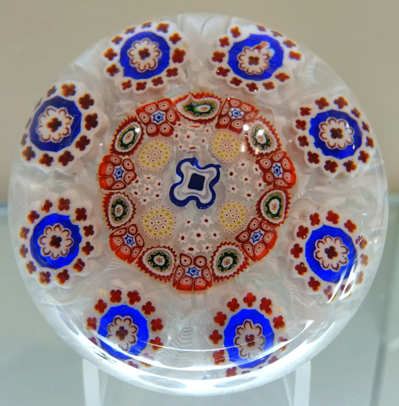 Paperweight enclosing concentric rings of white, purple and green millefiori canes above a purple and white stave basket, the outer ring formed of small white florets