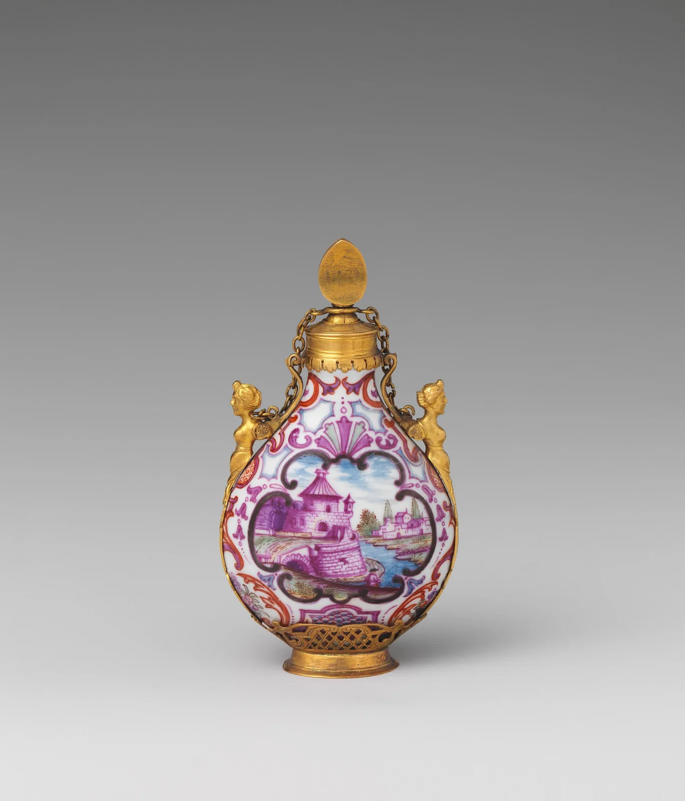 Small flattened pear-shaped porcelain bottle painted with a purple river landscape in a scrolled cartouche, mounted in gilt metal with a hinged cap on chains, female busts at the shoulders and a pierced foot rim