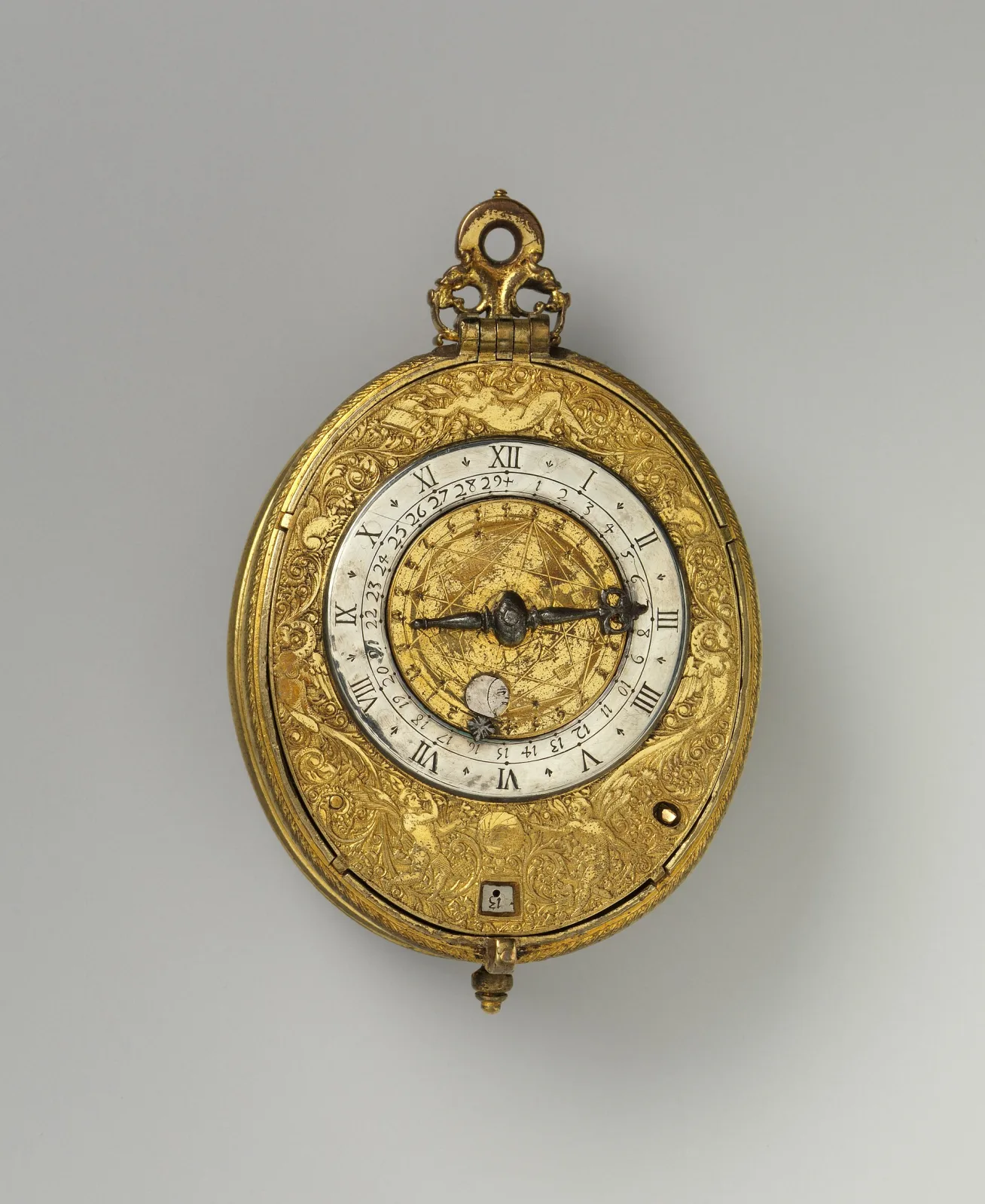 Oval gilt-brass watch with a silver chapter ring carrying Roman hours outside and numerals 1 to 31 inside, around an engraved gilt centre with a moon face