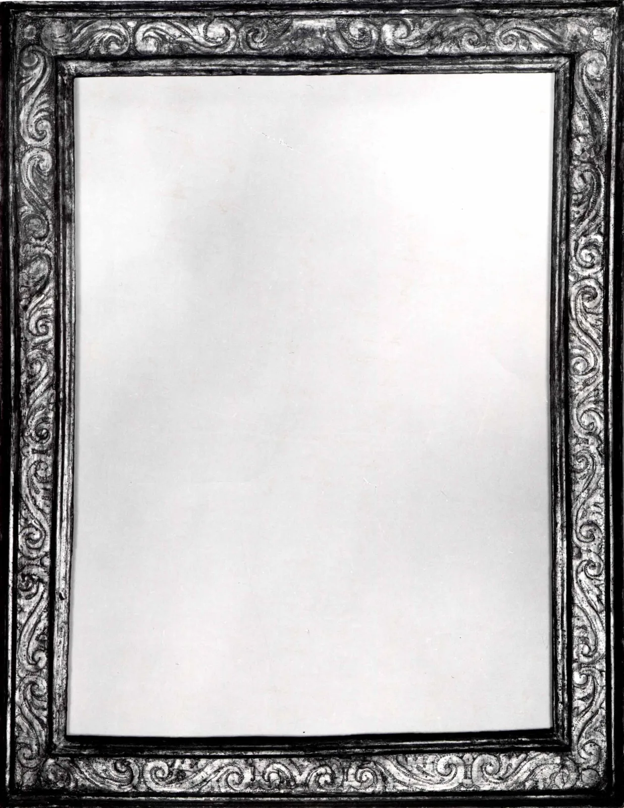 Early seventeenth-century cassetta frame photographed in black and white, the same flat profile but covered edge to edge with carved and punched scrolling foliage