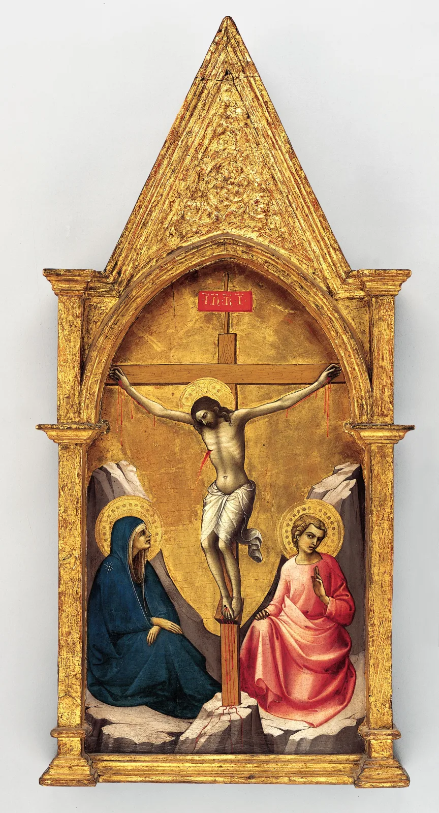 Gilded Gothic tabernacle frame of about 1404 with a steeply gabled top and twisted colonnettes, still holding its painted Crucifixion panel with figures on a gold ground