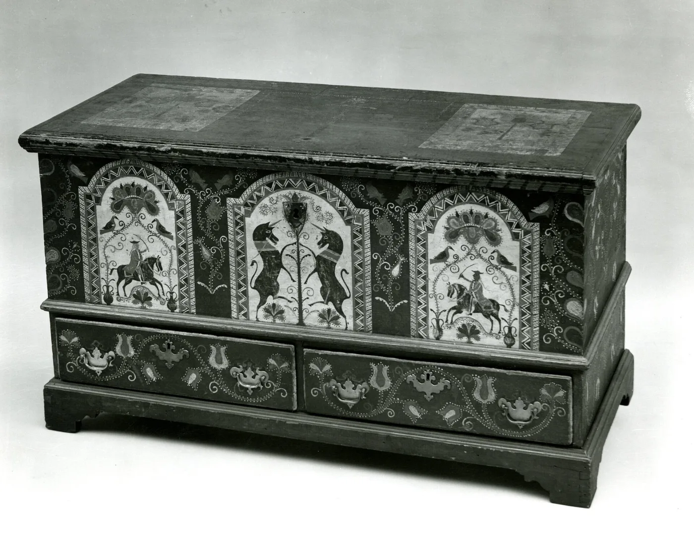 Pennsylvania German dower chest painted dark green with three white arched panels across the front, each holding facing unicorns and a flowering tree, over two drawers decorated with tulips