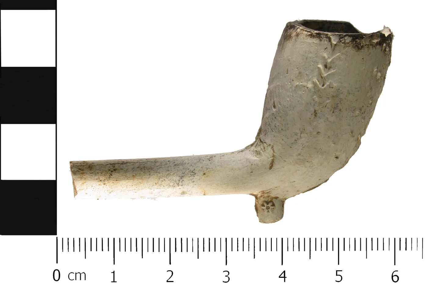 Larger clay pipe bowl tilted forward on a surviving stem, with a small pointed spur stamped with a rosette