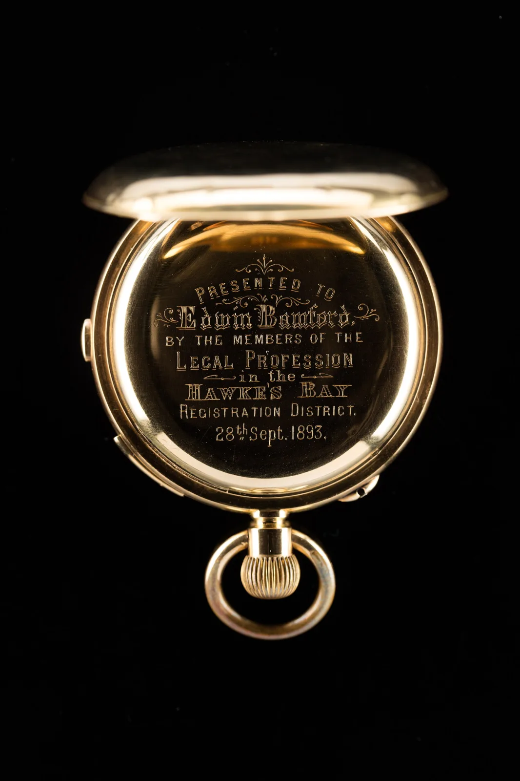 Inside of a gold watch case cover engraved in flowing script with a presentation inscription naming a recipient, the members of the legal profession, and a date in September 1855