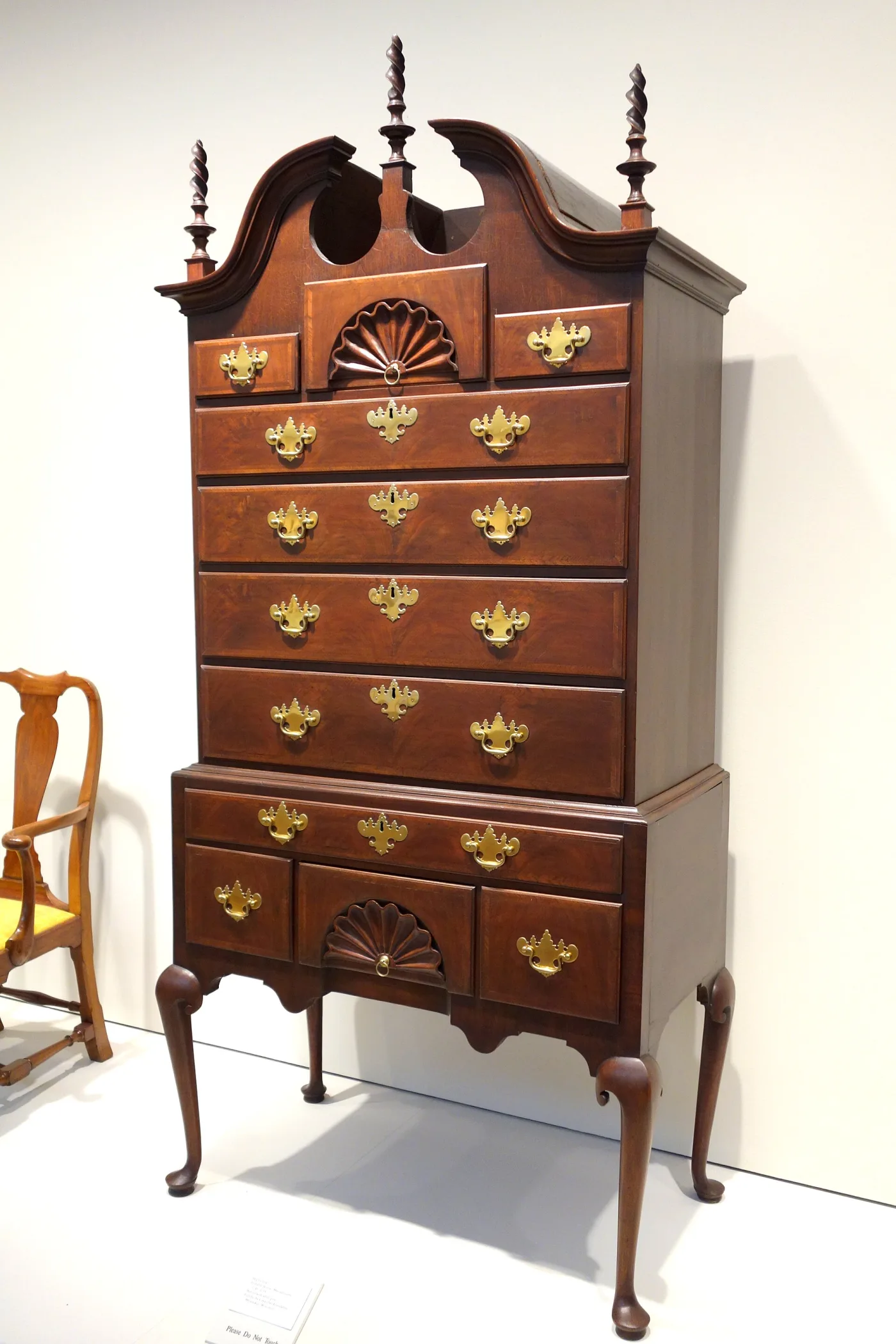 Walnut high chest with a broken-scroll bonnet top, three corkscrew finials, fan-carved centre drawers and cabriole legs on pad feet