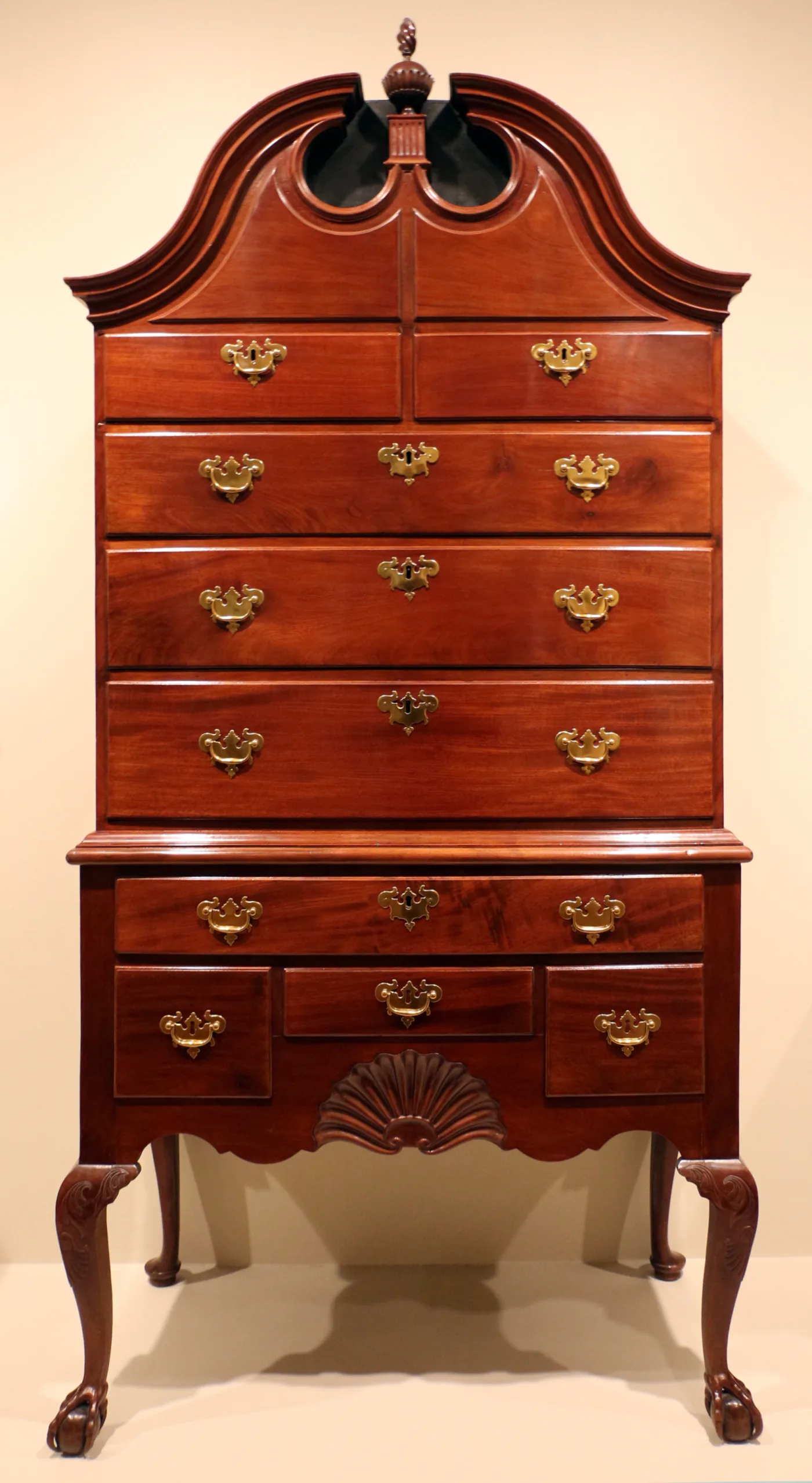 Mahogany high chest with a closed bonnet top, a carved shell on the skirt, carved acanthus knees and ball-and-claw front feet