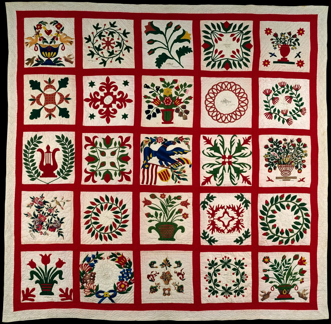 Album quilt of twenty-five appliqu&eacute;d blocks in red and green on white, divided by wide red sashing, with small handwritten inscriptions visible in several blocks