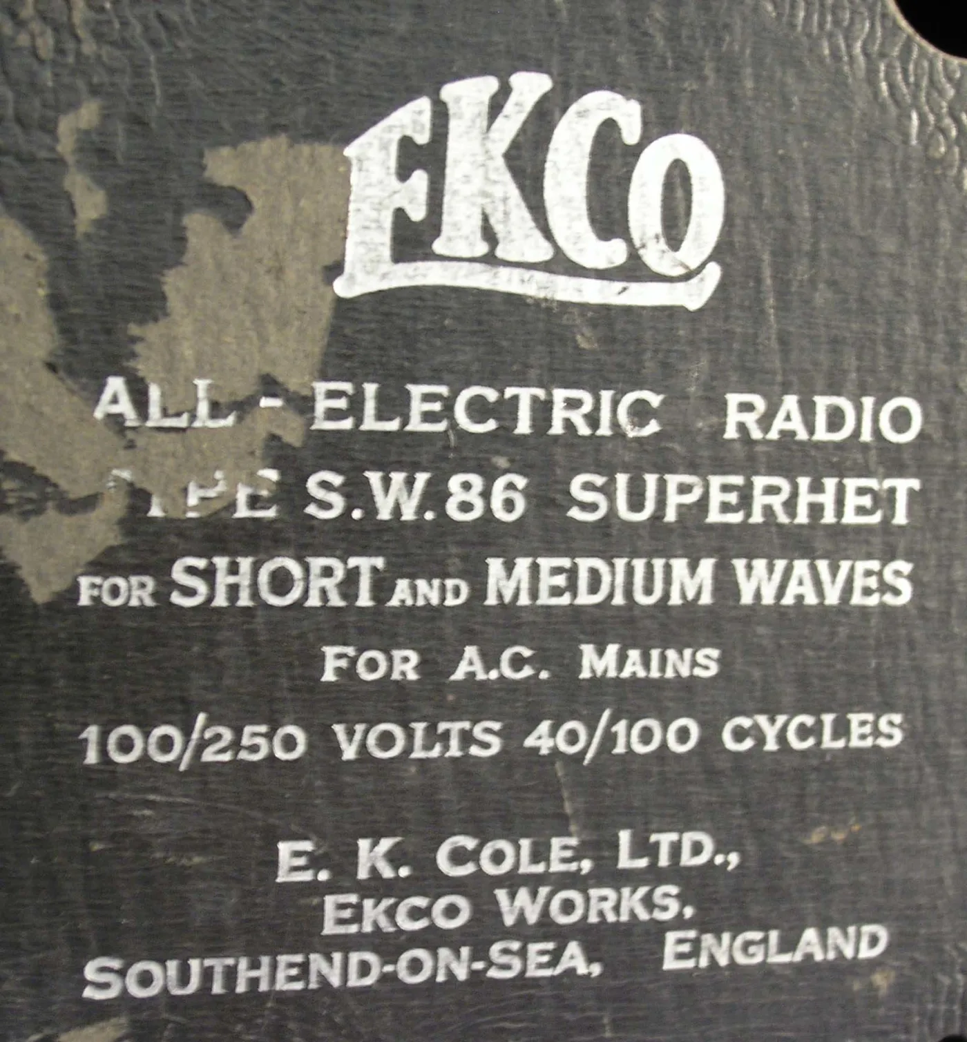 Close-up of a black back panel stencilled in white with the EKCO logo and the words All-Electric Radio Type S.W.86 Superhet for Short and Medium Waves