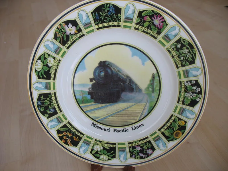 Circular service plate with a colour transfer of a steam locomotive at its centre, ringed by a border of state names each paired with its state flower
